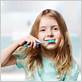 little girl brushing her teeth electric toothbrush